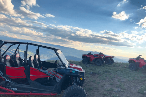 a group of people sitting around a car